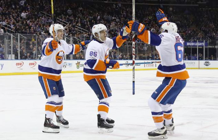 NEW YORK, NY - MARCH 22: The New York Islanders celebrate a powerplay goal by Nikolay Kulemin #86 (C) at 5:01 (C) of the third period against the New York Rangers at Madison Square Garden on March 22, 2017 in New York City. The Islanders defeated the Rangers 3-2. Joining Kulemin is h72#2 (L) and Joshua Ho-Sang #66 (R). — AFP