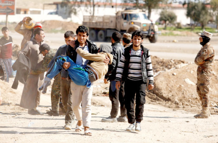 Displaced people are checked by Iraqi forces as Iraqi forces battle with Daesh militants, in western Mosul, Iraq, on Saturday. — Reuters