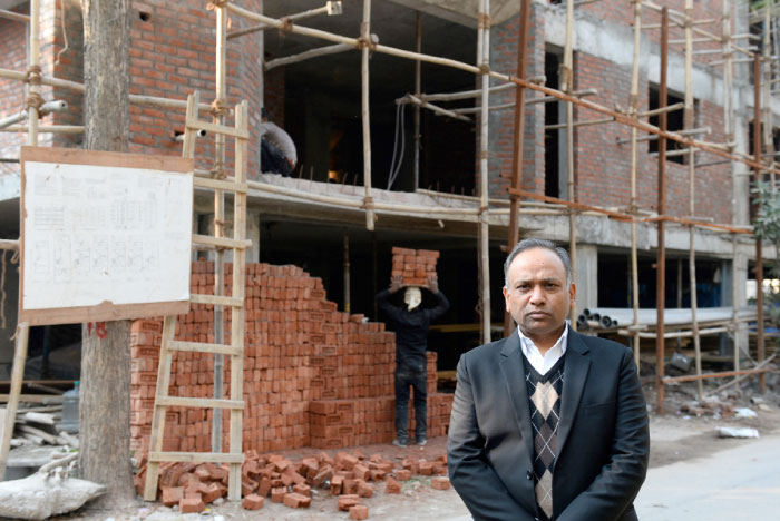 Indian lawyer Naresh Gupta poses outside an under-construction building in New Delhi in this Jan. 12, 2017 file photo. — AFP