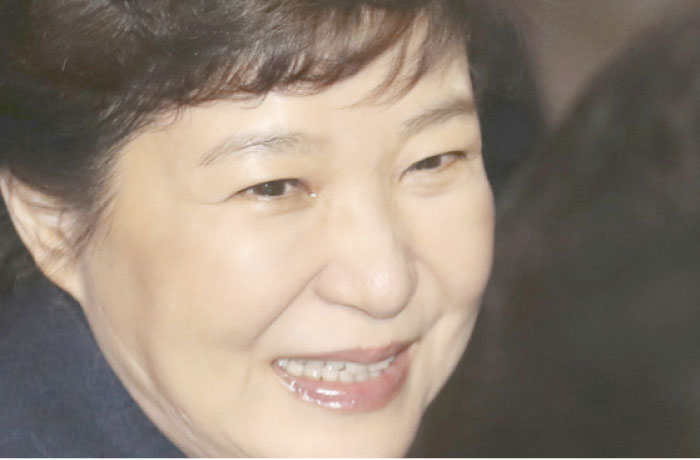 Ousted South Korean President Park Geun-hye smiles with watery eyes upon her arrival at her private home in Seoul on Sunday. — AP