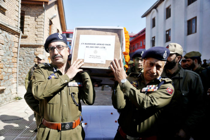 Indian police officers carry a coffin containing the body their colleague Manzoor Ahmad Naik during the wreath-laying ceremony at the police headquarters of Srinagar, India, on Sunday. — AP