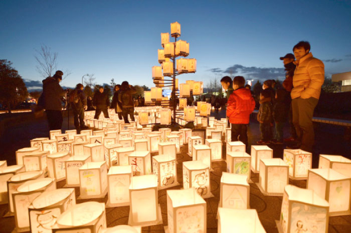 Visitors look at paper lanterns as part of a memorial service for victims of the 2011 quake-tsunami disaster in Natori, Miyagi prefecture, Japan, Saturday. — AFP