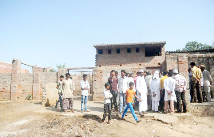 Indian Muslim butchers and traders with family members gather outside a closed illegal slaughterhouse at Naini in Allahabad, India, on Tuesday. — AFP