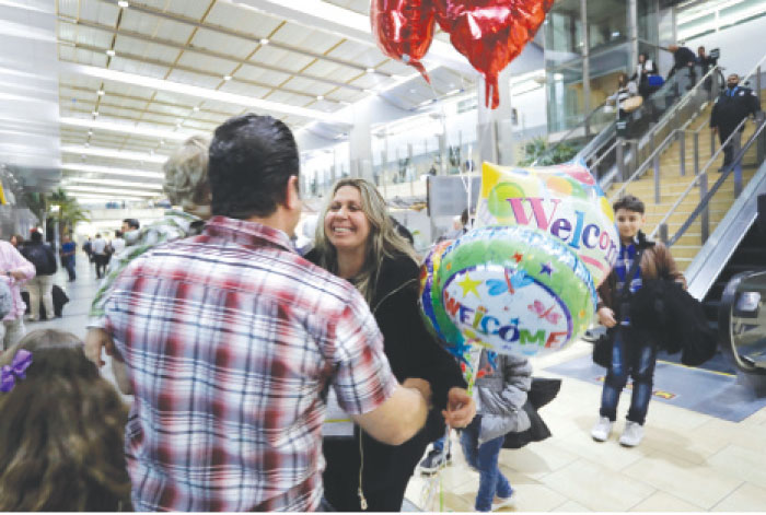 Nadia Hanan Madalo (center) hugs her brother Gassan Kakooz at the airport after arriving in San Diego from Iraq, Wednesday. — AP