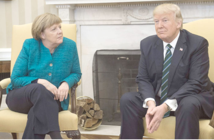 US President Donald Trump and German Chancellor Angela Merkel meet in the Oval Office of the White House in Washington, DC, on Friday. — AFP