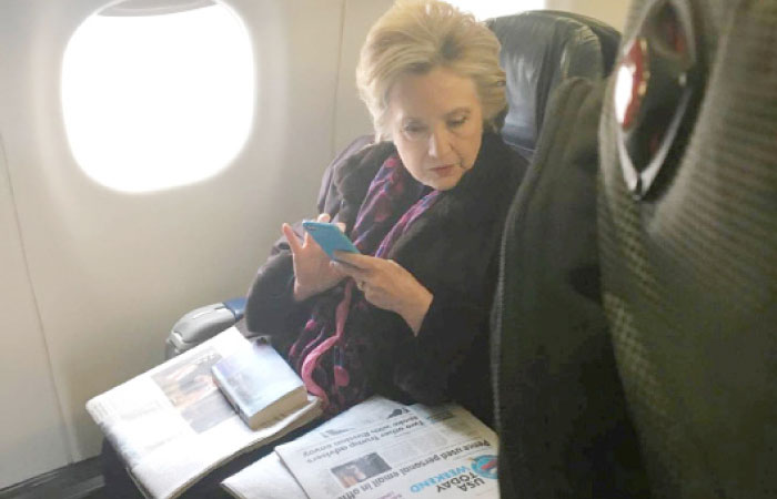 Former Democratic presidential candidate Hillary Clinton looks at a USA Today newspaper carrying an article about US Vice President Mike Pence’s use of personal email while in office, during her flight on American Airlines to Laguardia airport in New York City, New York, on Friday. — Reuters