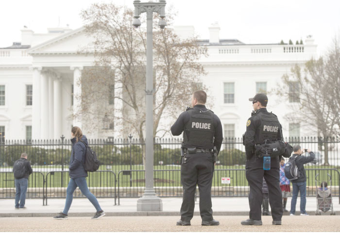 Members of the Secret Service Uniformed Divison patrol alongside the security fence around the perimeter of the White House in Washington on Saturday. — AFP