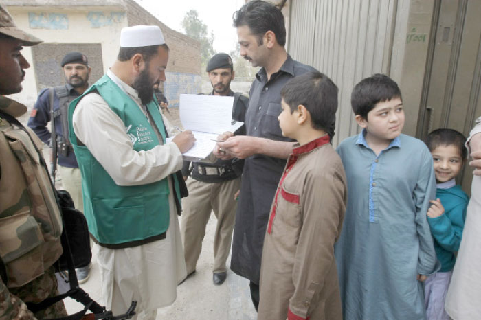 A government official collects data from a resident during a survey in Peshawar, Pakistan, on Wednesday. — AP