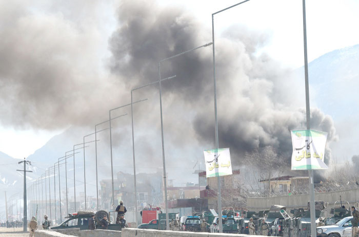Smoke rises from an Afghan police district headquarters building after a suicide car bombing in Kabul on Wednesday. — AFP