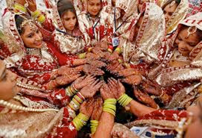 In an unrelated file photo brides pose as they display their hands decorated with henna during a mass marriage ceremony in Ahmedabad, India. — Reuters