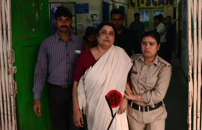 Indian police officials escort Chandana Chakraborty, center, from a police station in Jalpaiguri for a medical checkup to a hospital in the district of the eastern Indian state of West Bengal, after her arrest as part of an alleged child trafficking scandal in this Feb. 21, 2017 file photo. — AFP