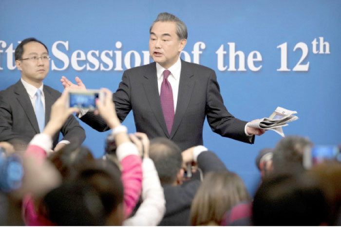 Chinese Foreign Minister Wang Yi gestures as he leaves following a press conference held on the sideline of the National People›s Congress at the media center in Beijing on Wednesday. — AP