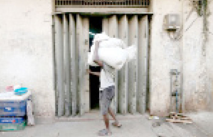 A labourer tries to open a door at a store room as he carries sacks of rice near a main market in Colombo, Sri Lanka, in this Feb. 21, 2017 file photo. — Reuters