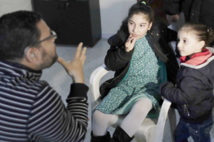 President of “Deaf Planet Soul” Chicago hearing charity, Gregory Perez, left, teaches sign language to Jana Faour, center, who was born deaf at Joub Jannine village in the Bekaa valley, east Lebanon. — AP