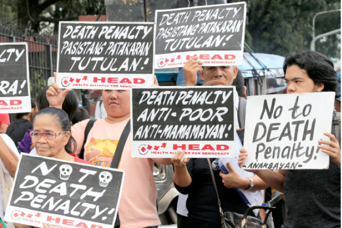 Activists holds placards during a protest rally against the passing of the death penalty bill, at the gate of House of the Representatives in Quezon city, metro Manila, Philippines, on Tuesday. — Reuters