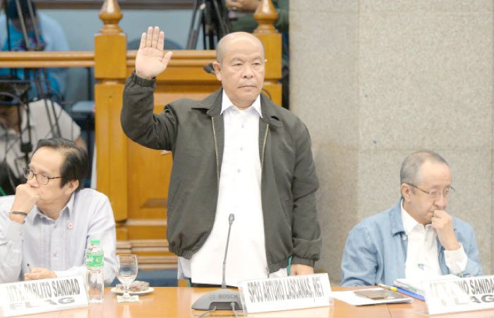 Retired police officer Arturo “Arthur” Lascanas takes his oath during a Senate hearing in Manila on Monday. — AFP