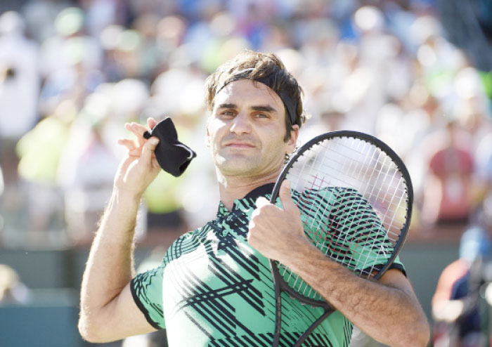 Roger Federer of Switzerland throws his wristband to fans in the stands as celebrates after defeating Stanislas Wawrinka of Switzerland in the men’s final of the BNP Paribas Open at Indian Wells Tennis Garden on Sunday.  — AFP