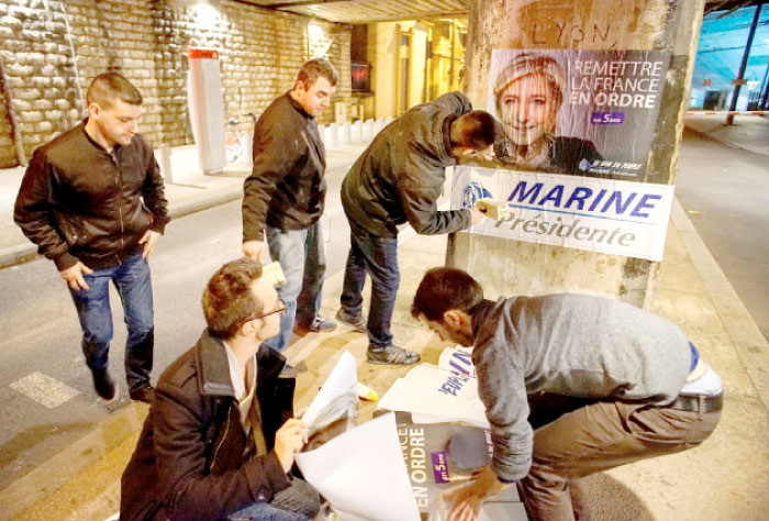 Members of the National Front youths put up posters of Marine Le Pen, French National Front (FN) political party leader and candidate for the French 2017 presidential election, ahead of a two-day FN political rally to launch the presidential campaign in Lyon, France, in this Feb.2, 2017 file photo. — Reuters