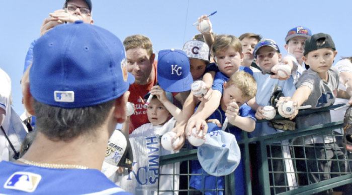 Fans ask for the autograph of Kansas City Royals right fielder Paulo Orlando before a spring training baseball game against the Chicago Cubs in Mesa, Ariz., Sunday. — AP