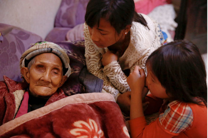 Refugees who fled fighting in neighboring Myanmar talk to a 96-year-old family member the house of a relative in the village of Baiyan near Nansan in the Yunnan province, China, on Saturday. — Reuters