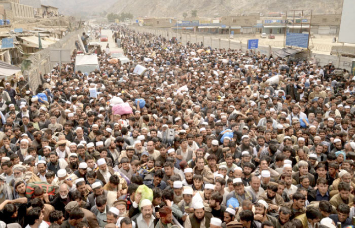 Afghan nationals prepare to cross the Torkham border post in Pakistan en route to Afghanistan on Tuesday. — AP