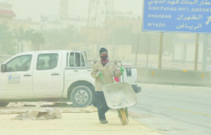 An expatriate working in dusty weather in Dammam on Monday. — Okaz photo