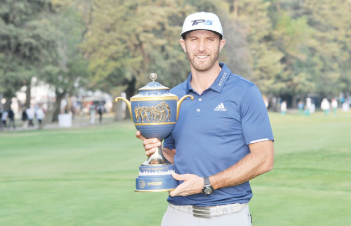 Dustin Johnson poses with the winner’s trophy following the final round of the WGC - Mexico Championship golf tournament at Club de Golf Chapultepec. — AFP