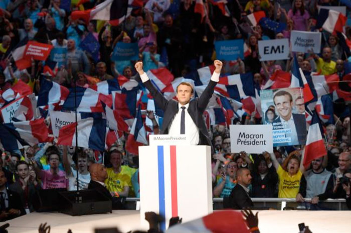 file photo taken on April 17, 2017 shows Presidential election candidate for the En Marche ! movement Emmanuel Macron raising his fists on stage during a campaign meeting at the Bercy Arena in Paris. Macron is the clear favourite to become France's youngest-ever president after topping. — AFP