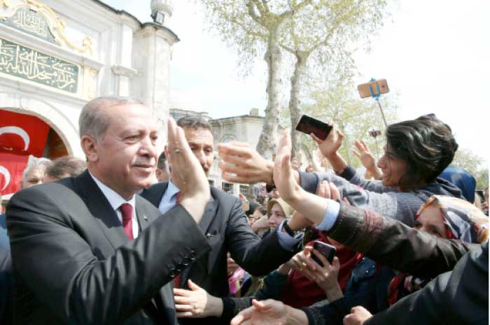 Turkish President Tayyip Erdogan greets his supporters as he leaves Eyup Sultan mosque in Istanbul, Turkey, Monday. — Reuters