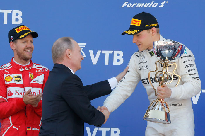 Russian President Vladimir Putin congratulates Russian Grand Prix winner and Mercedes Formula One driver Valtteri Bottas of Finland as second-placed Ferrari Formula One driver Sebastian Vettel of Germany stands nearby on the podium in Sochi Sunday. — Reuters