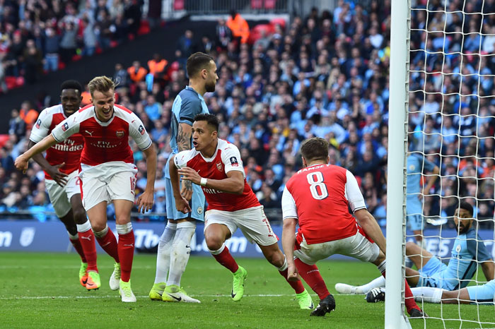 Arsenal's striker Alexis Sanchez (C) celebrates scoring the second goal during the FA Cup semifinal match against Manchester City at Wembley Stadium in London Sunday. — AFP