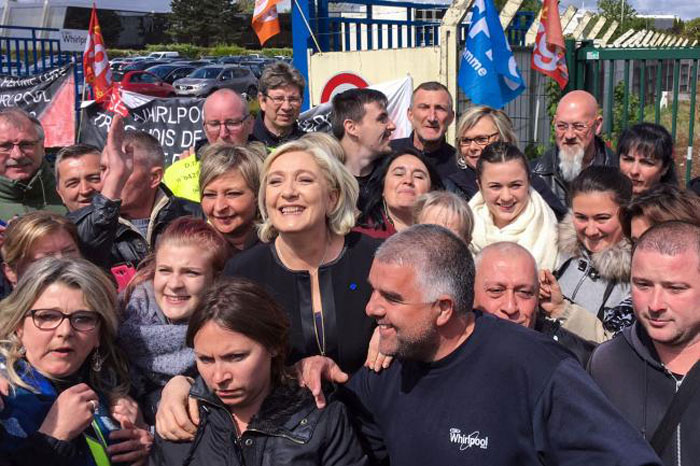 French presidential election candidate for the far-right Front National (FN) party, Marine Le Pen, center, smiles with people in front of the Whirlpool factory in Amiens, northern France, on Wednesday. — AFP