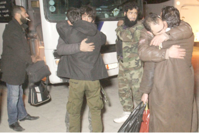 Syrians embrace as buses transporting Syrians evacuated from two besieged rebel-held towns of Madaya and Zabadani arrive in Idlib late as part of a deal between the opposition and the Syrian government. — AFP