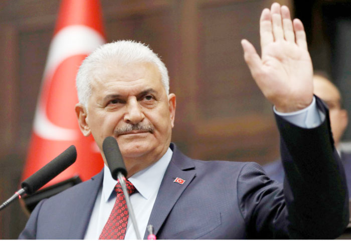 Turkey’s Prime Minister Binali Yildirim addresses members of parliament from his ruling AK Party (AKP) as he arrives for a meeting at the Turkish parliament on Tuesday in Ankara. — AFP