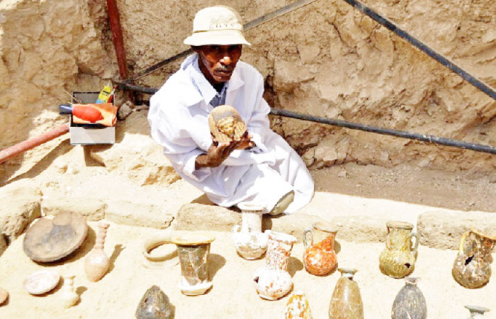 A member of an Egyptian archeological team shows artifacts discovered in a 3,500-year-old tomb in the Draa Abul Nagaa necropolis, near the southern city of Luxor, last week. — AFP