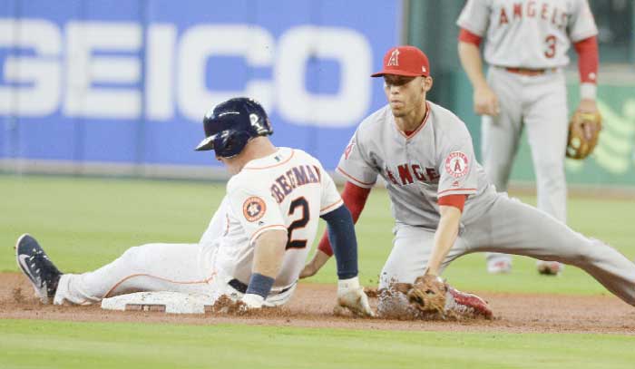 Houston Astros’ Alex Bregman (L) slides into second base for a double as Los Angeles Angels’ Andrelton Simmons is late with the tag during their MLB game in Houston Thursday. — AP