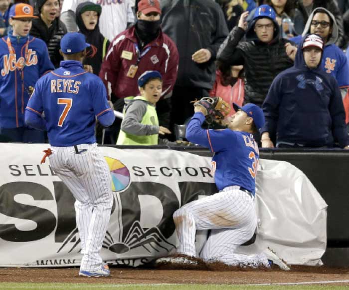 New York Mets left fielder Michael Conforto, right, catches a foul ball while third baseman Jose Reyes looks on during the sixth inning of the baseball game against the Washington Nationals at Citi Field, Sunday in New York. — AP