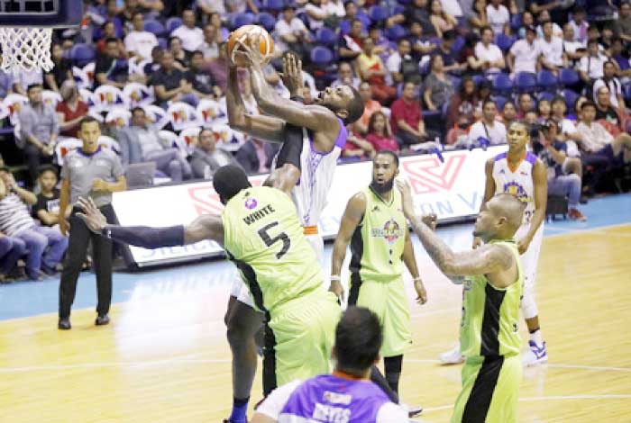 TNT’s Donte Green forces a shot off GlobalPort’s Malcolm White in their PBA Commissioner’s Cup game at the Smart-Araneta Coliseum Friday night.