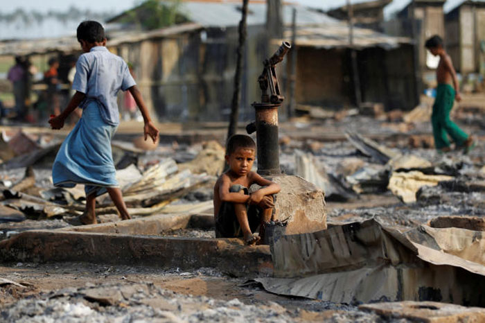 A boy sit in a burned area after fire destroyed shelters at a camp for internally displaced Rohingya Muslims in the western Rakhine State near Sittwe, Myanmar, in this May 3, 2016 file photo. — Reuters