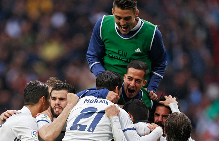 Real Madrid players celebrate their side's second goal against Valencia during their Spanish La Liga soccer match at the Santiago Bernabeu Stadium in Madrid Saturday. — AP