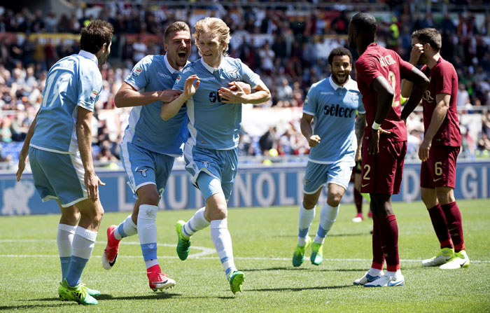 Lazio's Dusan Basta (3rd L) celebrates with teammates after scoring against Roma during their Serie A match at the Rome Olympic Stadium Sunday. — AP