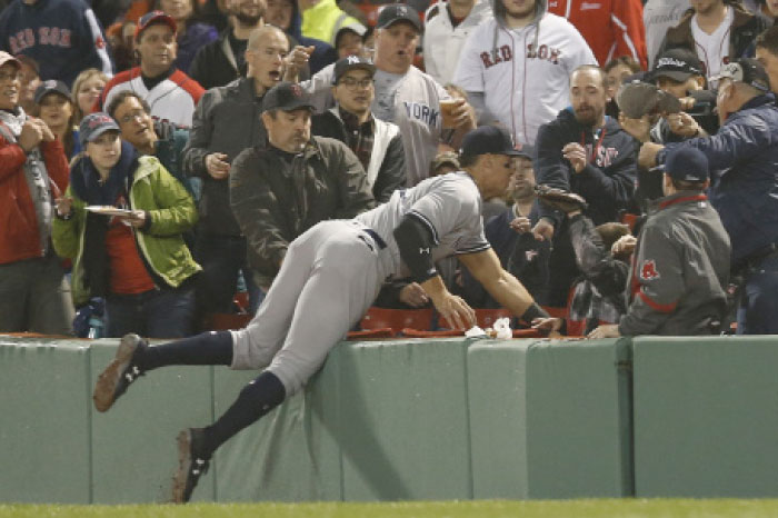 New York Yankees’ right fielder Aaron Judge dives into the stands to catch a fly ball against Boston Red Sox during their MLB game at Fenway Park in Boston Wednesday. — Reuters