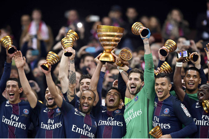 PSG’s defender Thiago Silva (C) holds the trophy as he celebrates with teammates after winning the French League Cup at the Parc Olympique Lyonnais Stadium in Decines-Charpieu, near Lyon, Saturday. — AFP