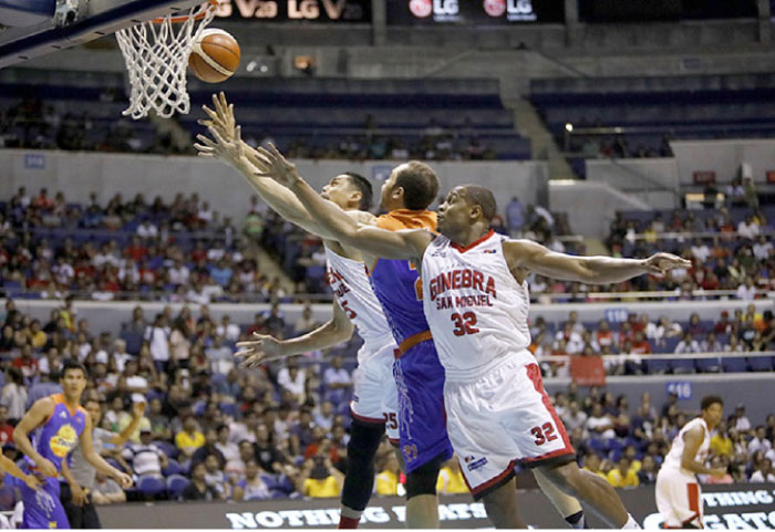 Ginebra’s Justin Brownless (No. 32) and Japeth Aguilar (No. 25) sandwich TNT’s Kelly Williams who tries to squeeze in a shot in their PBA Commissioner’s Cup game at the Smart-Araneta Coliseum Sunday night.