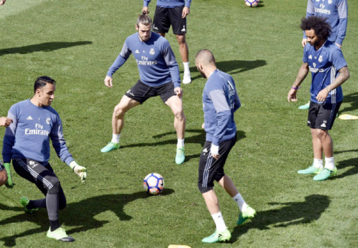 (From L) Real Madrid’s goalkeeper Keylor Navas, Gareth Bale, Karim Benzema and Marcelo eye a ball during a training session at Valdebebas training ground in Madrid Saturday. — AFP