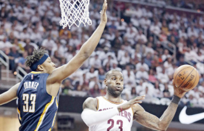 Cleveland Cavaliers’ LeBron James passes the ball past Indiana Pacers’ Myles Turner in Game 1 of their NBA playoff match in Cleveland Saturday. — AP