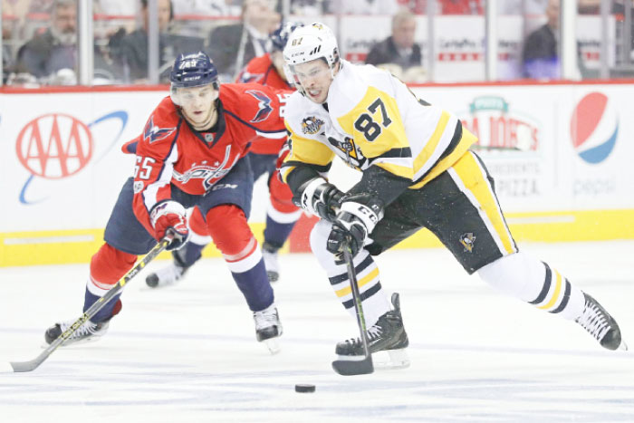 Sidney Crosby (R) of the Pittsburgh Penguins skates past Andre Burakovsky of the Washington Capitals in Game One of their NHL Playoffs at Verizon Center in Washington Thursday. — AFP