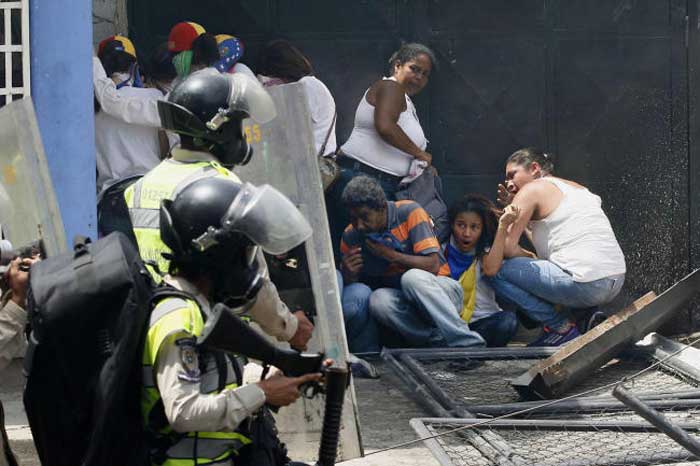 Anti-government demonstrators take cover from advancing Bolivarian Police officers during protests in Caracas, Venezuela, in this April 19, 2017 file photo. — AP