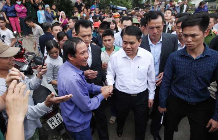 Hanoi’s Mayor Nguyen Duc Chung, third right, is greeted by villagers at Dong Tam commune, My Duc district in Hanoi, on Saturday. — AFP