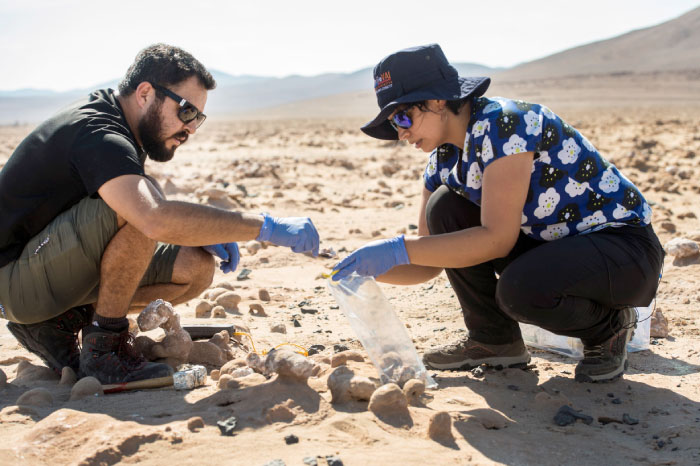 Chilean biologists Cristiana Dorador and Jonathan Garcia search for rock samples to analyze them in Yungay, Atacama desert, some 80 kms south of Antofagasta, Chile. — AFP